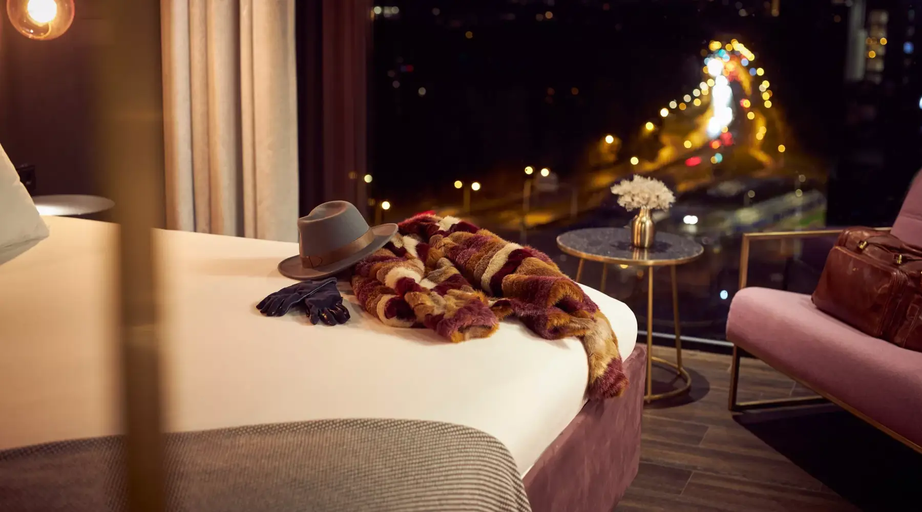 Jas hoed en handschoenen op bed in Van der Valk