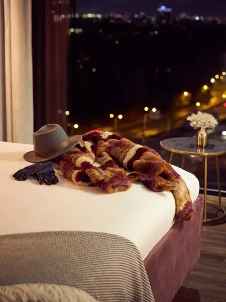 Manteau chaud et chapeau sur le lit d'hôtel