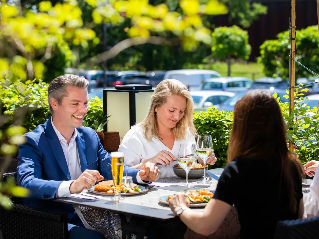 Gäste auf einer Terrasse des Hotels Eindhoven