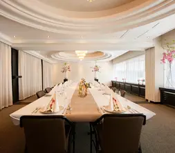 De Strausszaal sfeervol ingericht in een dineropstelling met een lange, feestelijk gedekte tafel en bloemdecoraties.