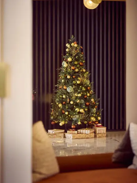 Festliche Weihnachtsstimmung mit geschmücktem Weihnachtsbaum, Schlitten und Weihnachtsdekoration im Van der Valk Hotel Gent – ideal für einen zauberhaften Aufenthalt während der Feiertage.