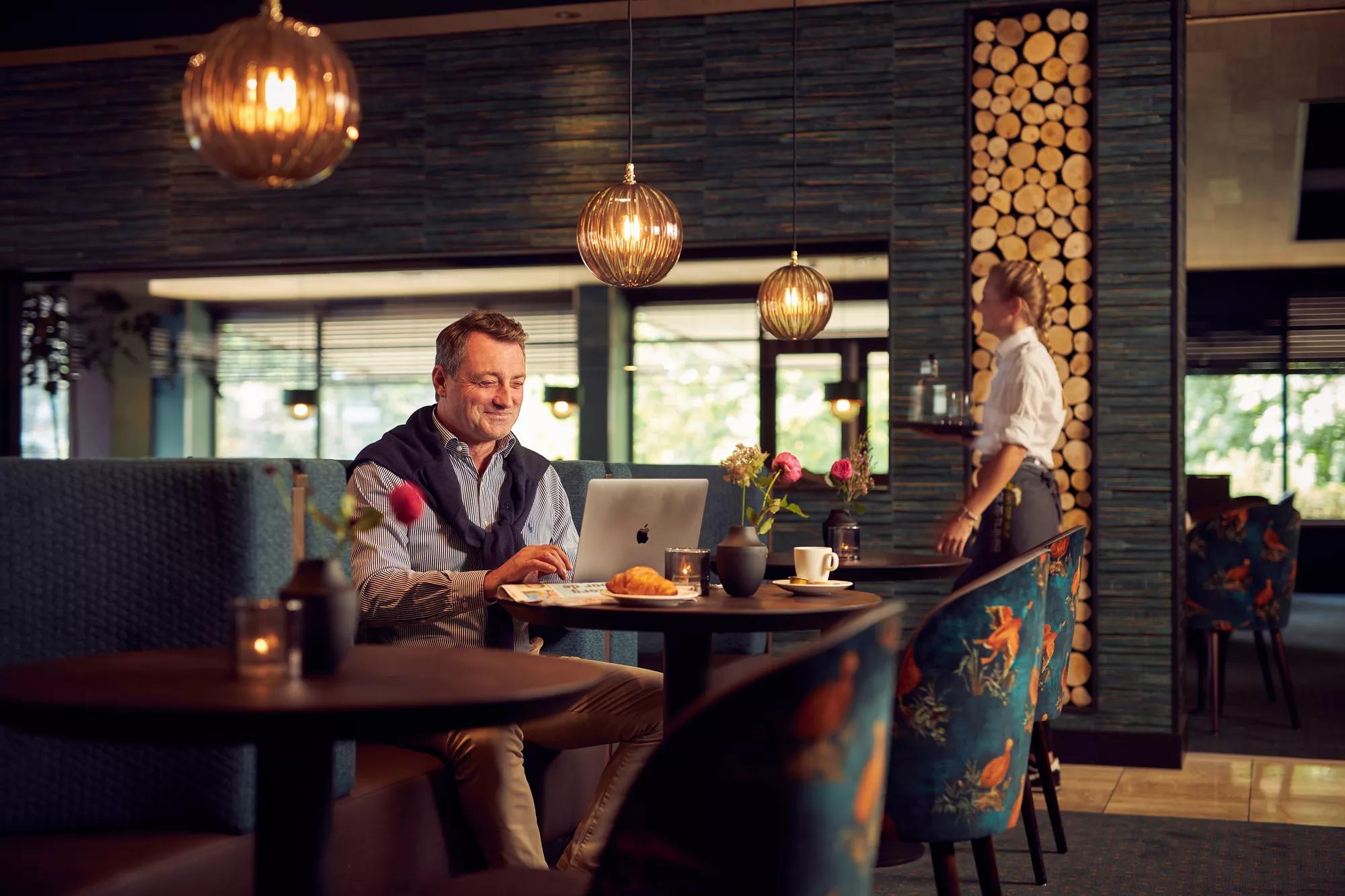 Man die aan het flexwerken is in hotelrestaurant