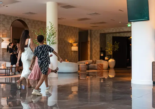 Frau mit Kindern laufen in der Lobby.