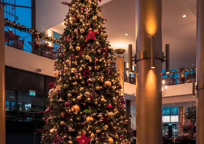 Kindje met een cadeau bij de kerstboom