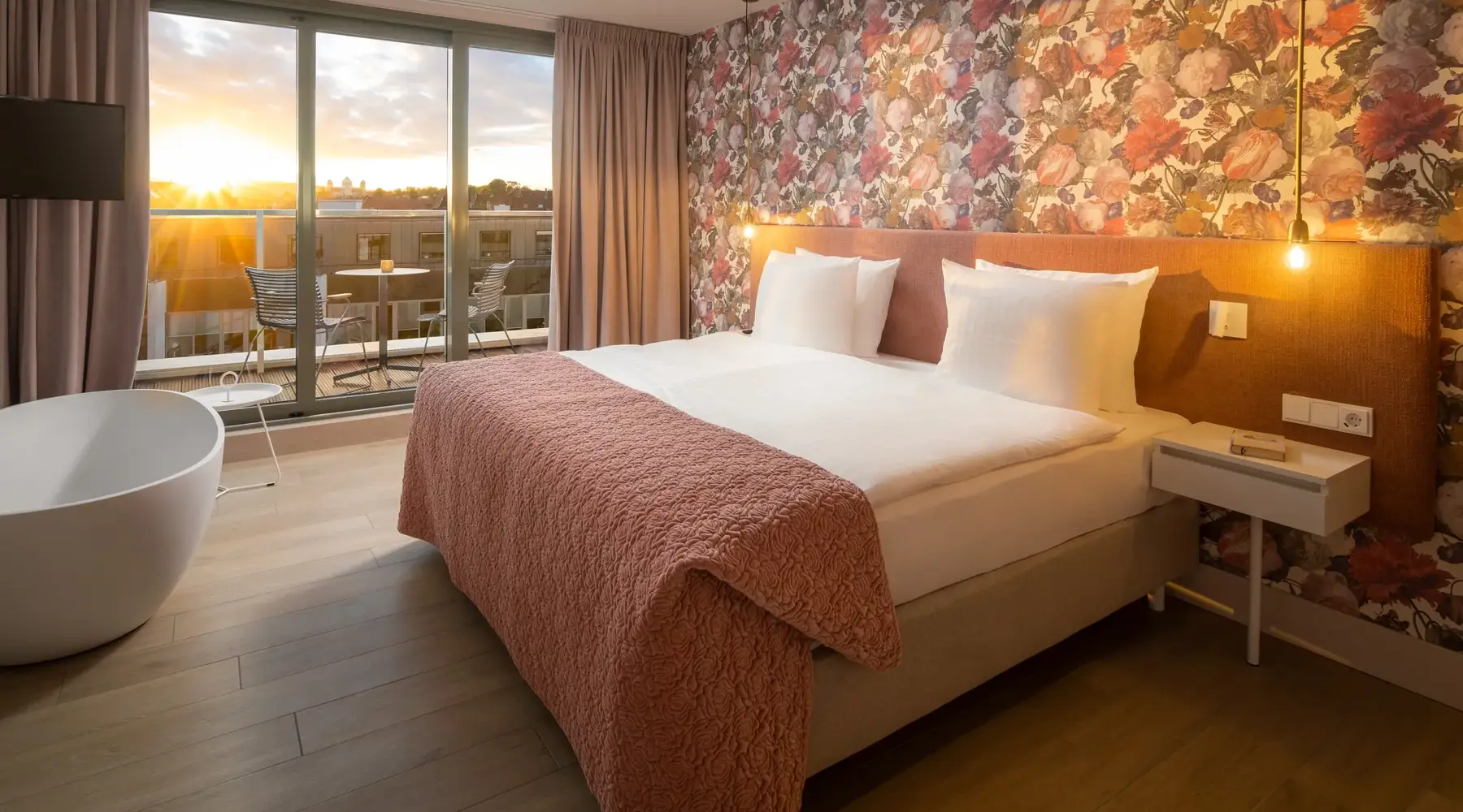 Unsere Rosa Suite. Man kann hier das große Bett, die freistehende Badewanne und den Balkon mit einem Herrlichen Sonnenuntergang