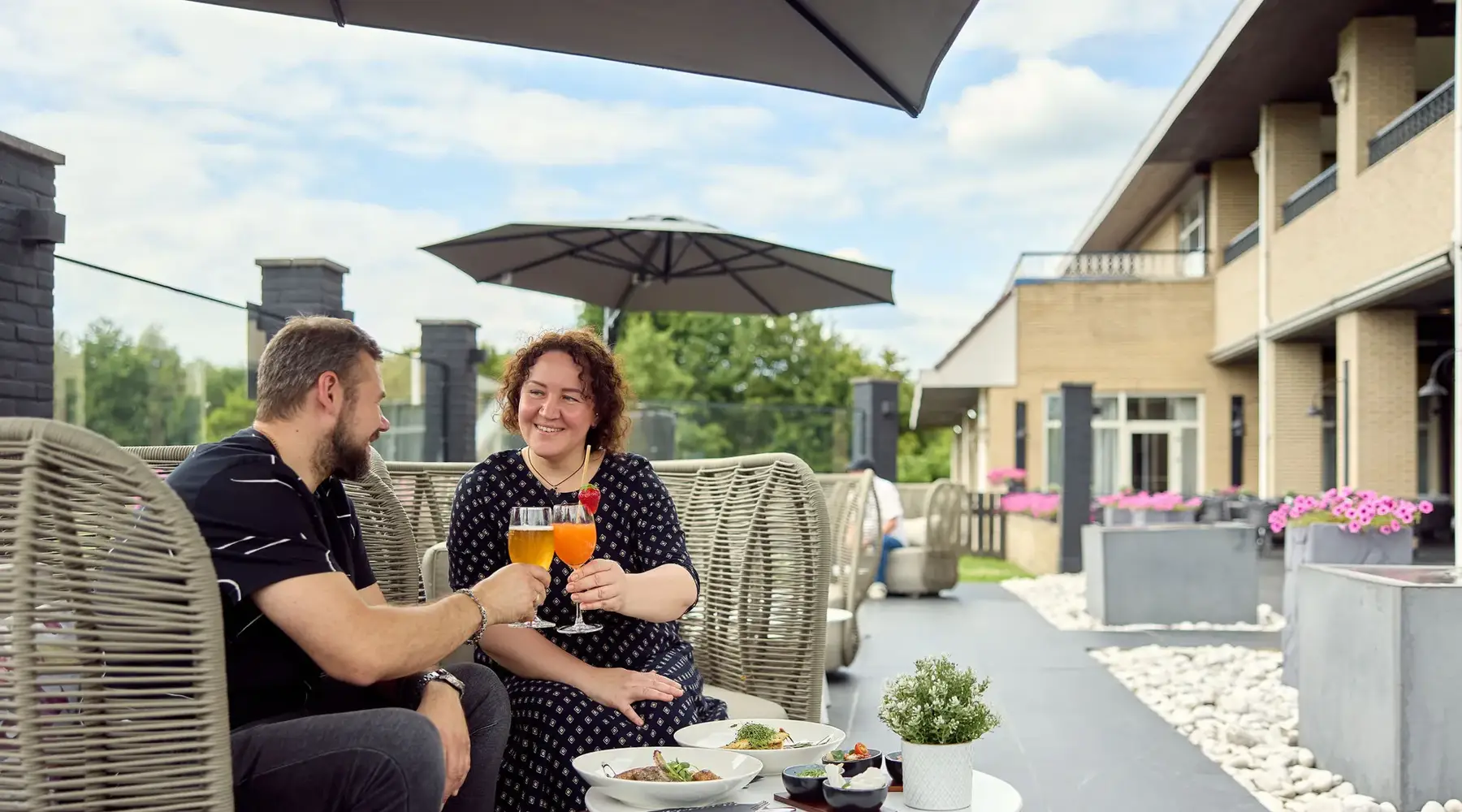Mann und Frau stoßen auf der Terrasse an