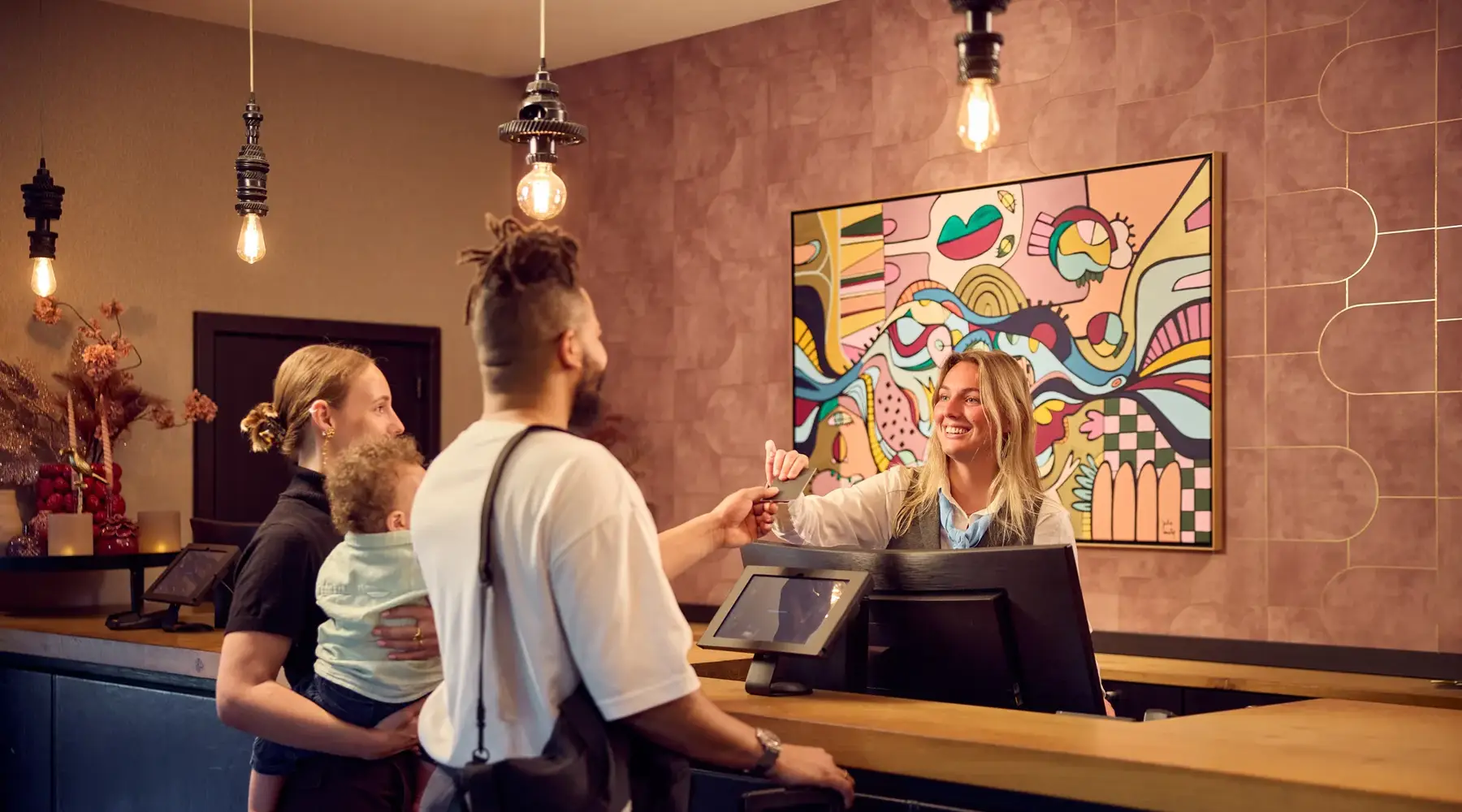 Les invités s'enregistrent auprès d'une réceptionniste d'un hôtel Van der Valk.