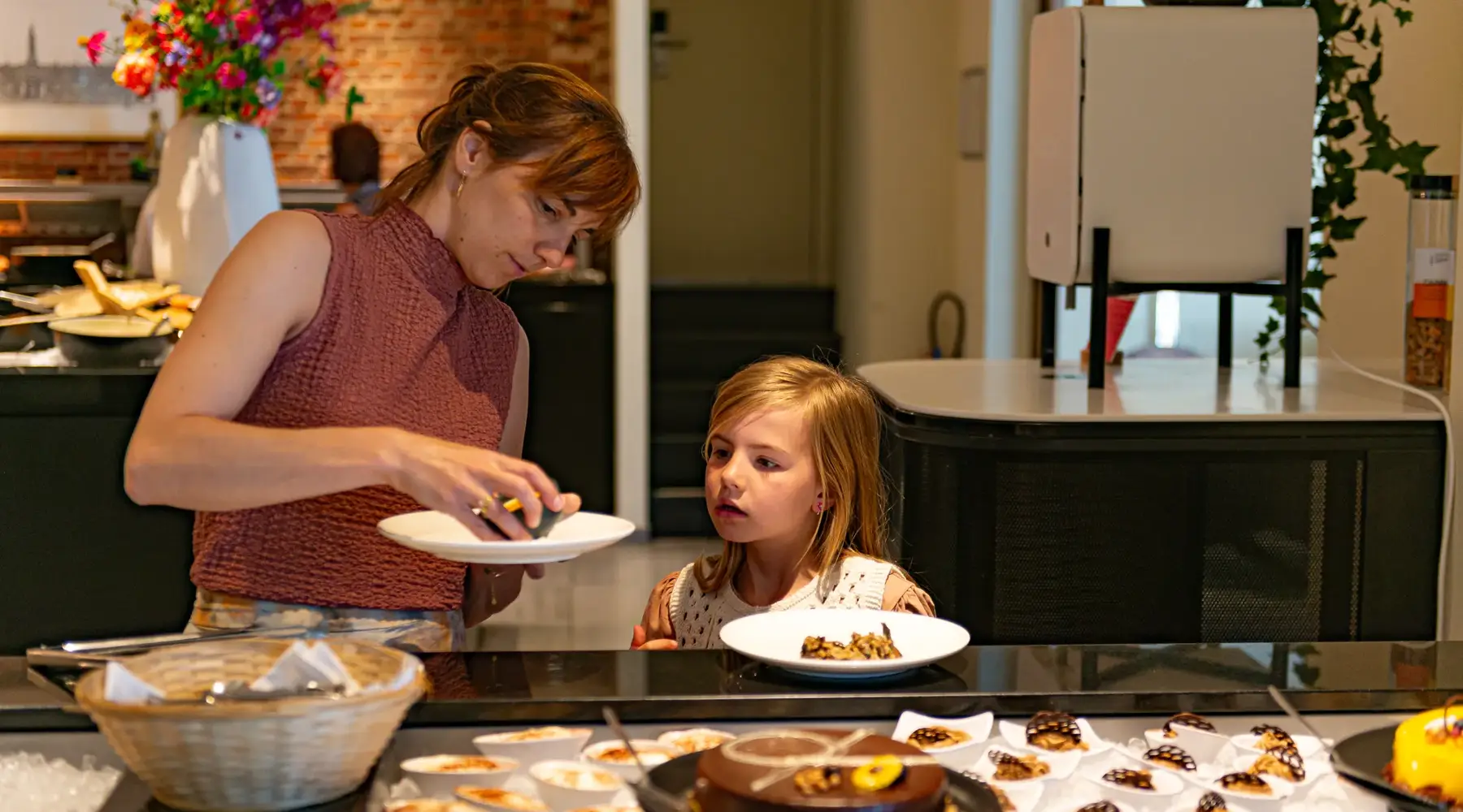 Een mama met haar dochter aan het dessertenbuffet.