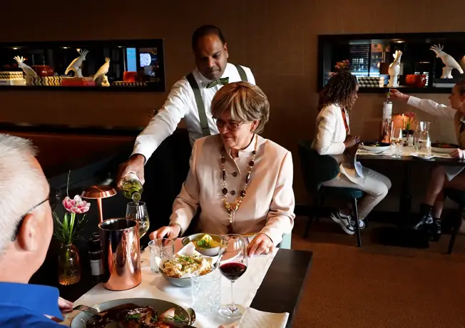 Ober serveert gerechten in restaurant De Valkenier