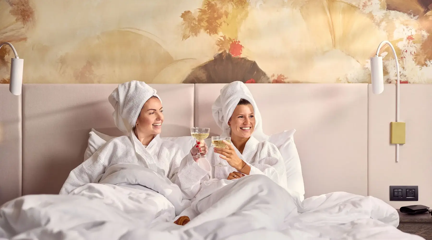 Vrouw die ontbijt op het hotelbed