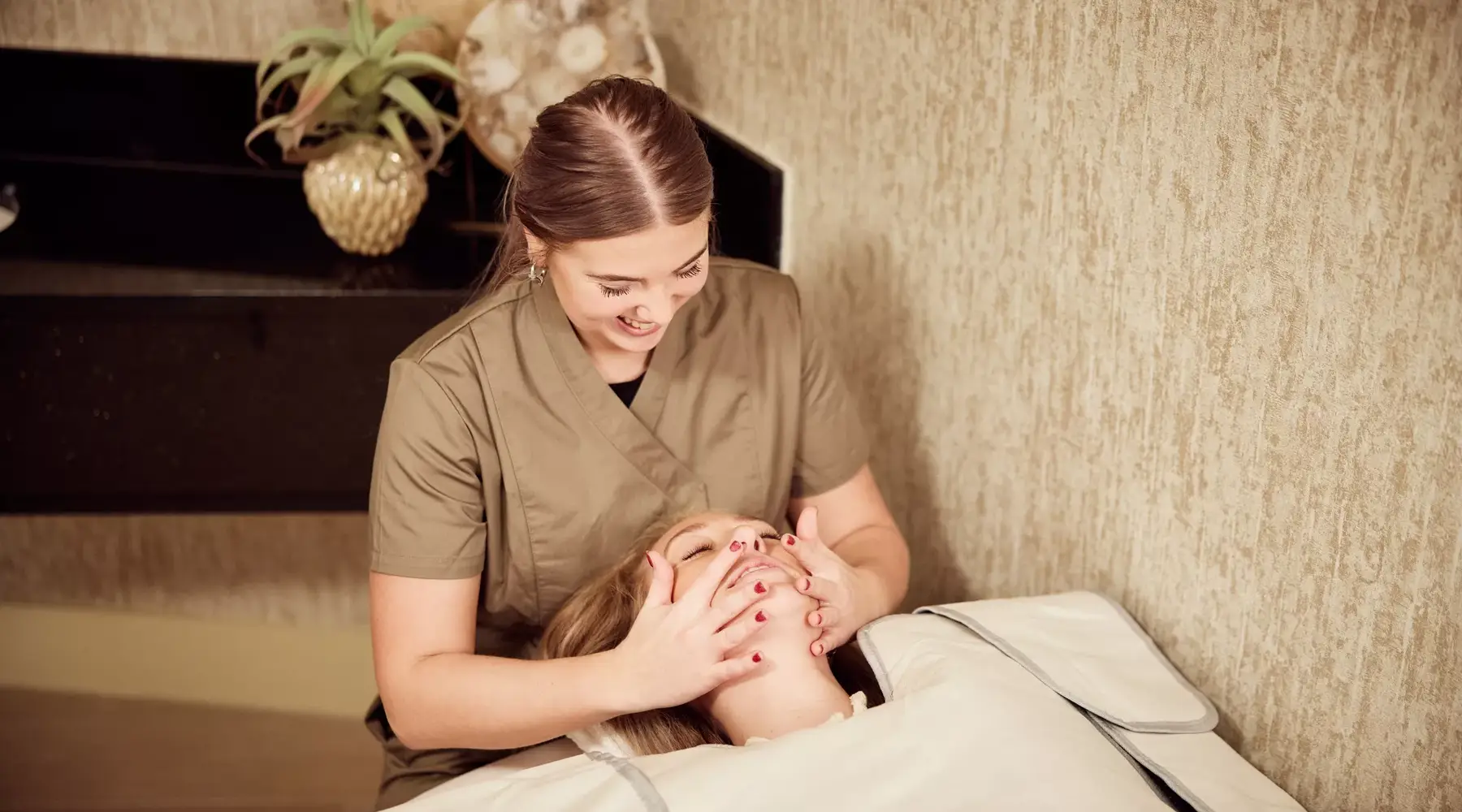 Une femme reçoit un massage du visage dans un salon de beauté