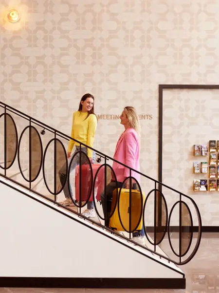 2 Damen mit Koffer auf einer Treppe