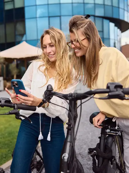 2 femmes partant à vélo de l'Hôtel Gent vers le centre