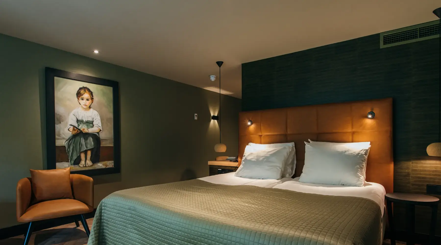 Bed in comfortable hotel room with green bedspread