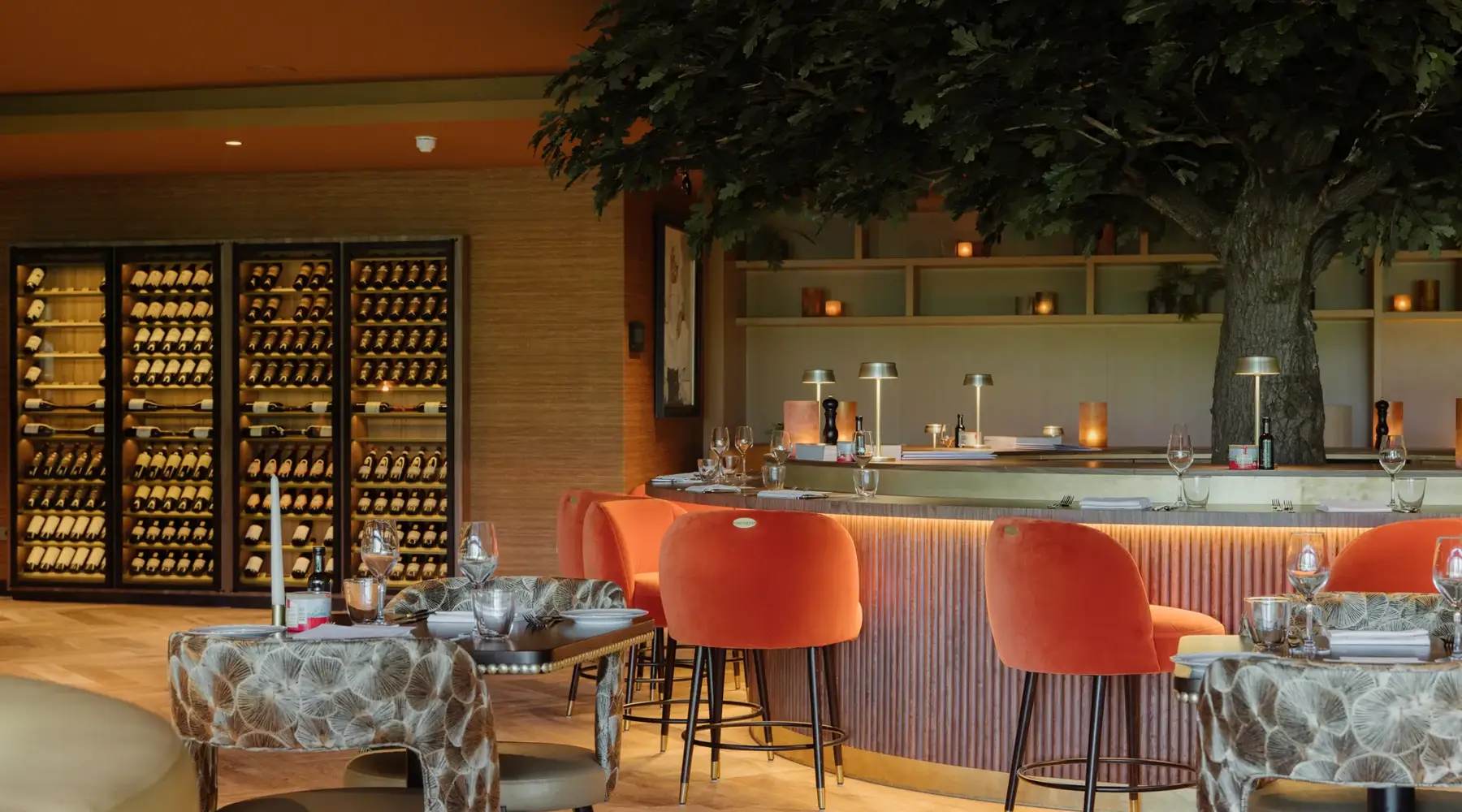 Bistro Martinus Bar met grote oranje barkrukken en zicht op de wijnkasten