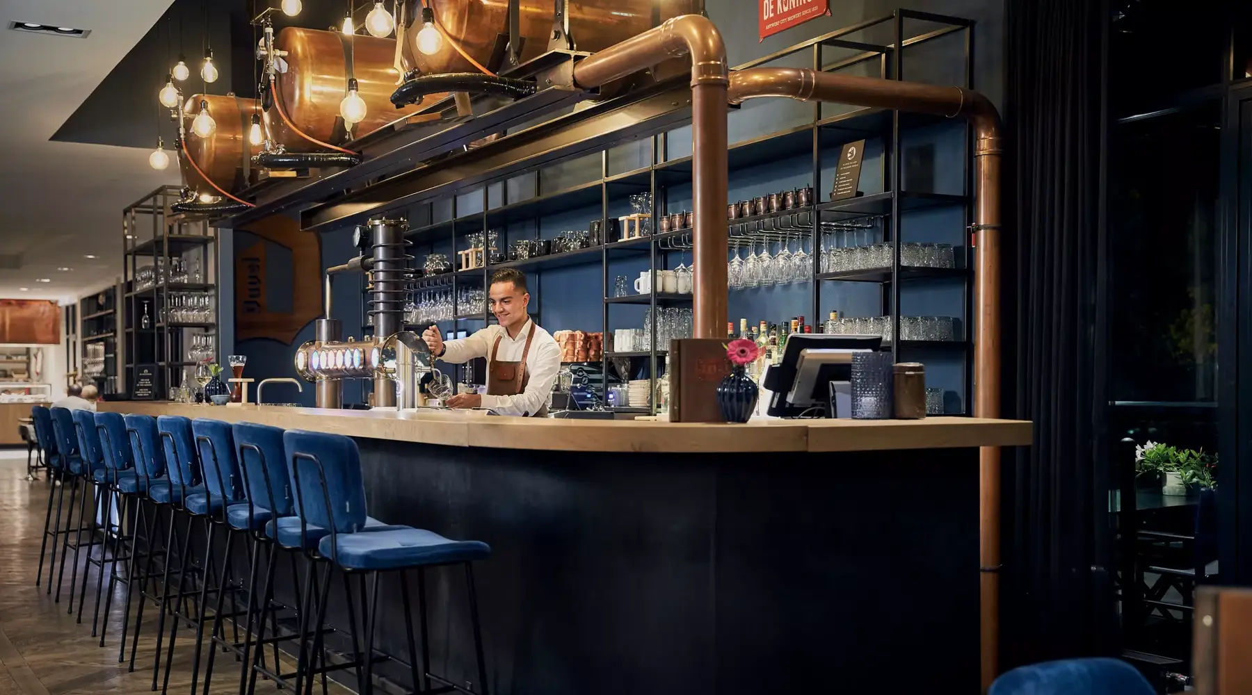 werknemer achter de bar tapt een biertje