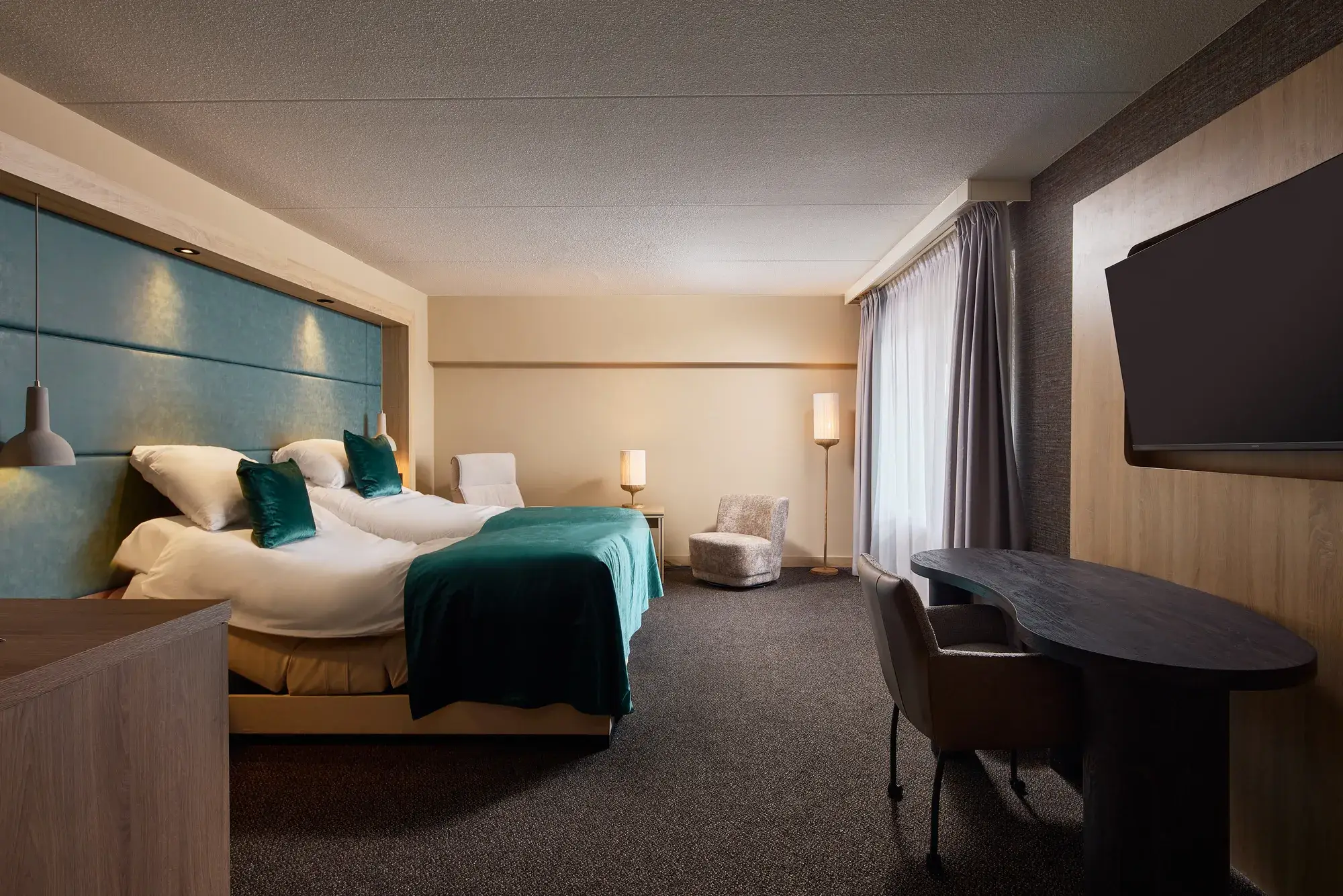 Comfortabel tweepersoonsbed met sfeervolle verlichting in een moderne hotelkamer van Van der Valk Hotel Leusden-Amersfoort