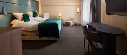 Comfortabel tweepersoonsbed met sfeervolle verlichting in een moderne hotelkamer van Van der Valk Hotel Leusden-Amersfoort