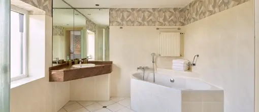 Luxe badkamer met ligbad, ruime wastafel en inloopdouche in de familiekamer