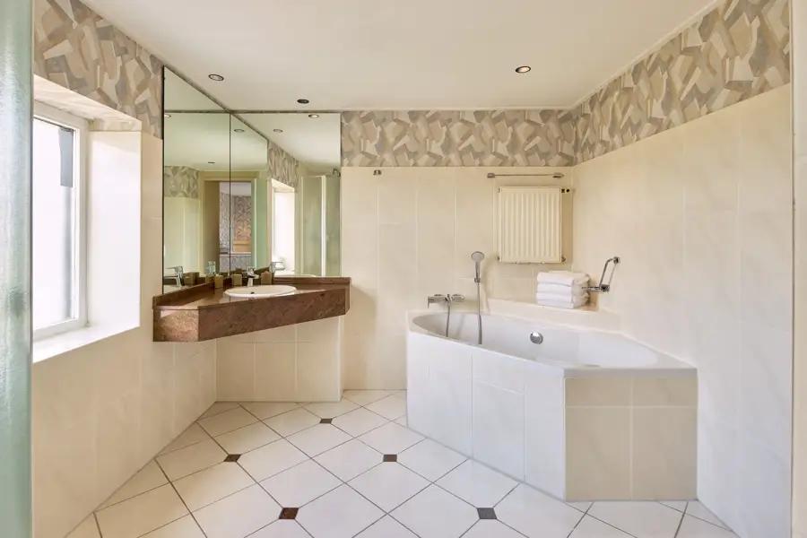 Salle de bains luxueuse avec baignoire, lavabo spacieux et douche à l'italienne dans la pièce familiale.