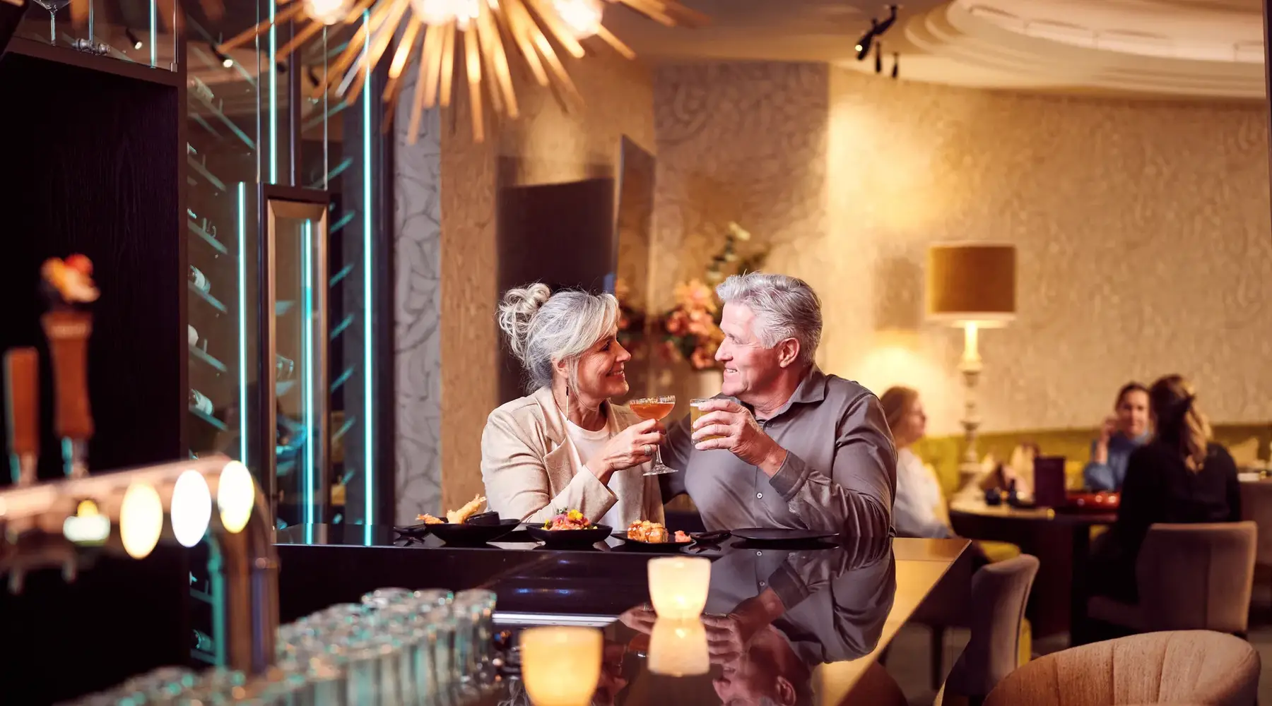 Homme et femme toastant dans un bar d'hôtel avec une boisson