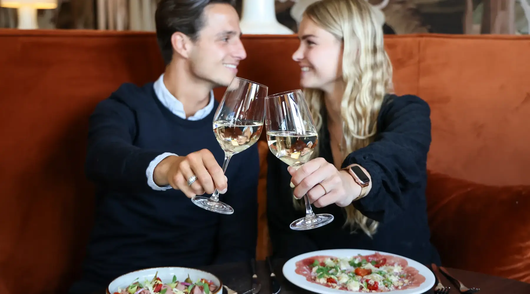 Man en vrouw klinken twee glazen wijn 