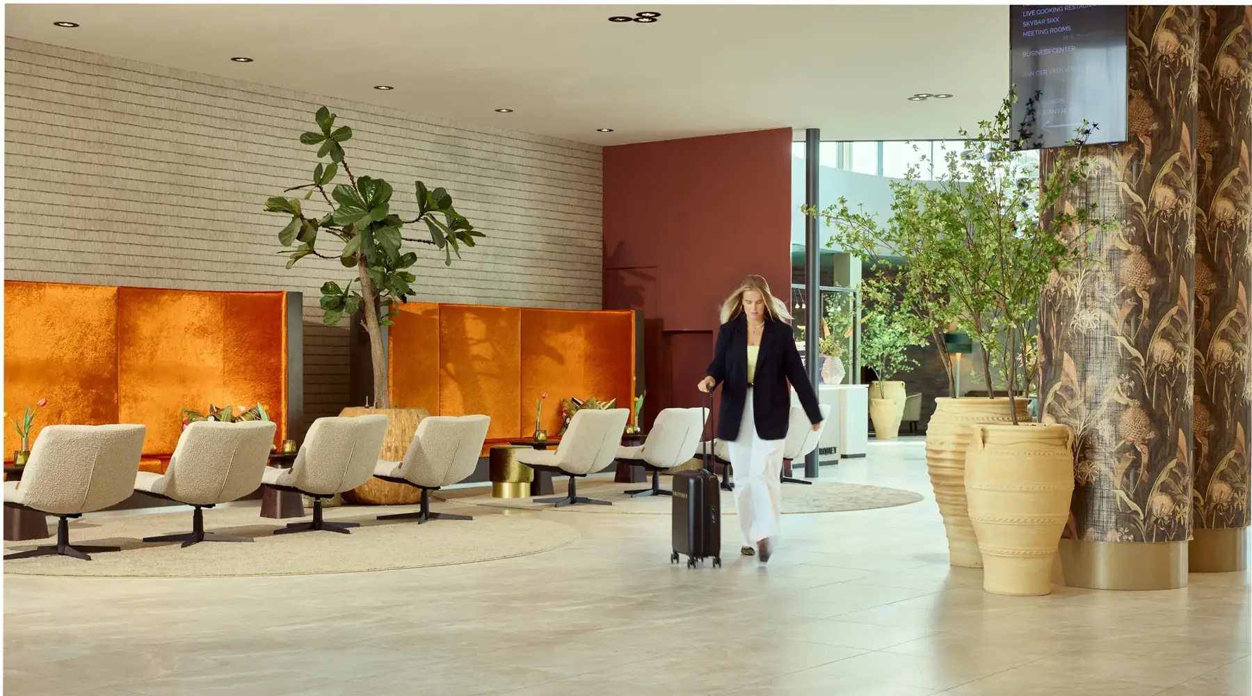 Frau läuft mit Trolley durch Business Center.