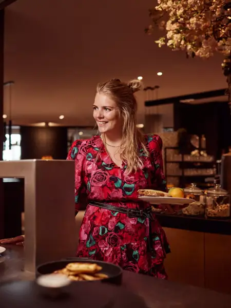 Frau holt Essen vom Buffet