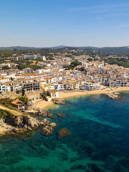 Spanish coast with many houses, a rocky beach, and an azure blue sea