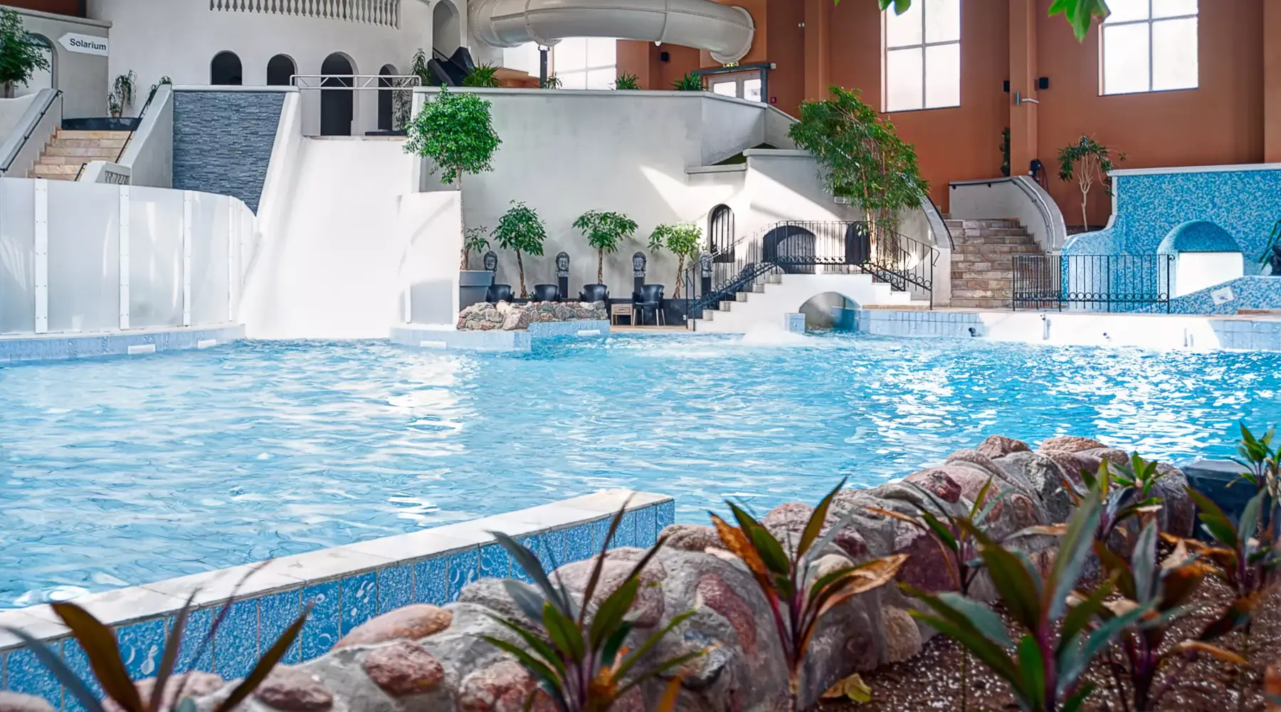 Hallenbad mit Rutsche und Liegestühlen im Van der Valk Resort Linstow.