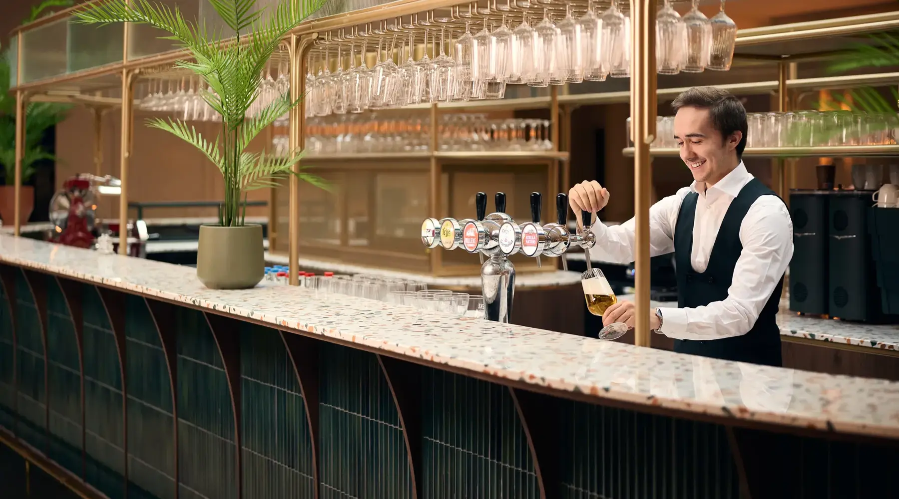 barman die een biertje tapt bij de bar