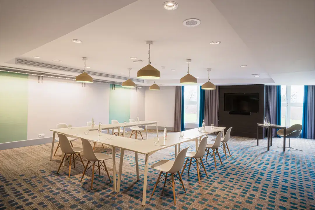 Une salle créative et moderne avec un motif en zigzag au sol, des accents industriels et des touches de jaune créant une ambiance dynamique.