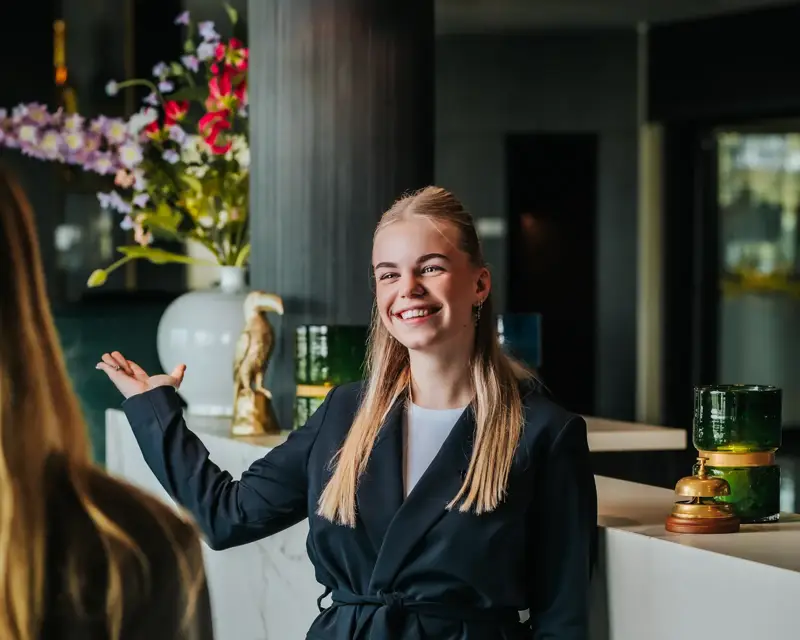 Freundinnen checken an der Rezeption eines Hotels ein.