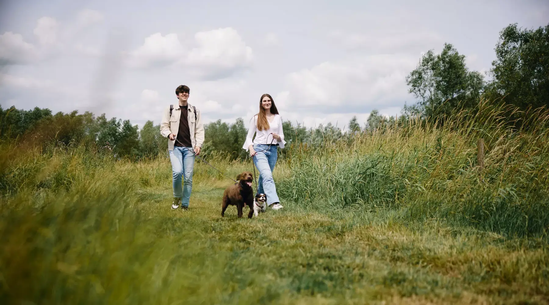 Mutter und Tochter gehen mit dem Hund spazieren.