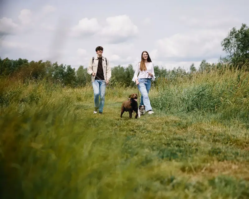 Mutter und Tochter gehen mit dem Hund spazieren.