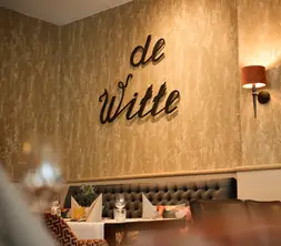 Detail of the interior with the atmospheric wall decoration by de Witte, situated above a comfortable upholstered console bench.