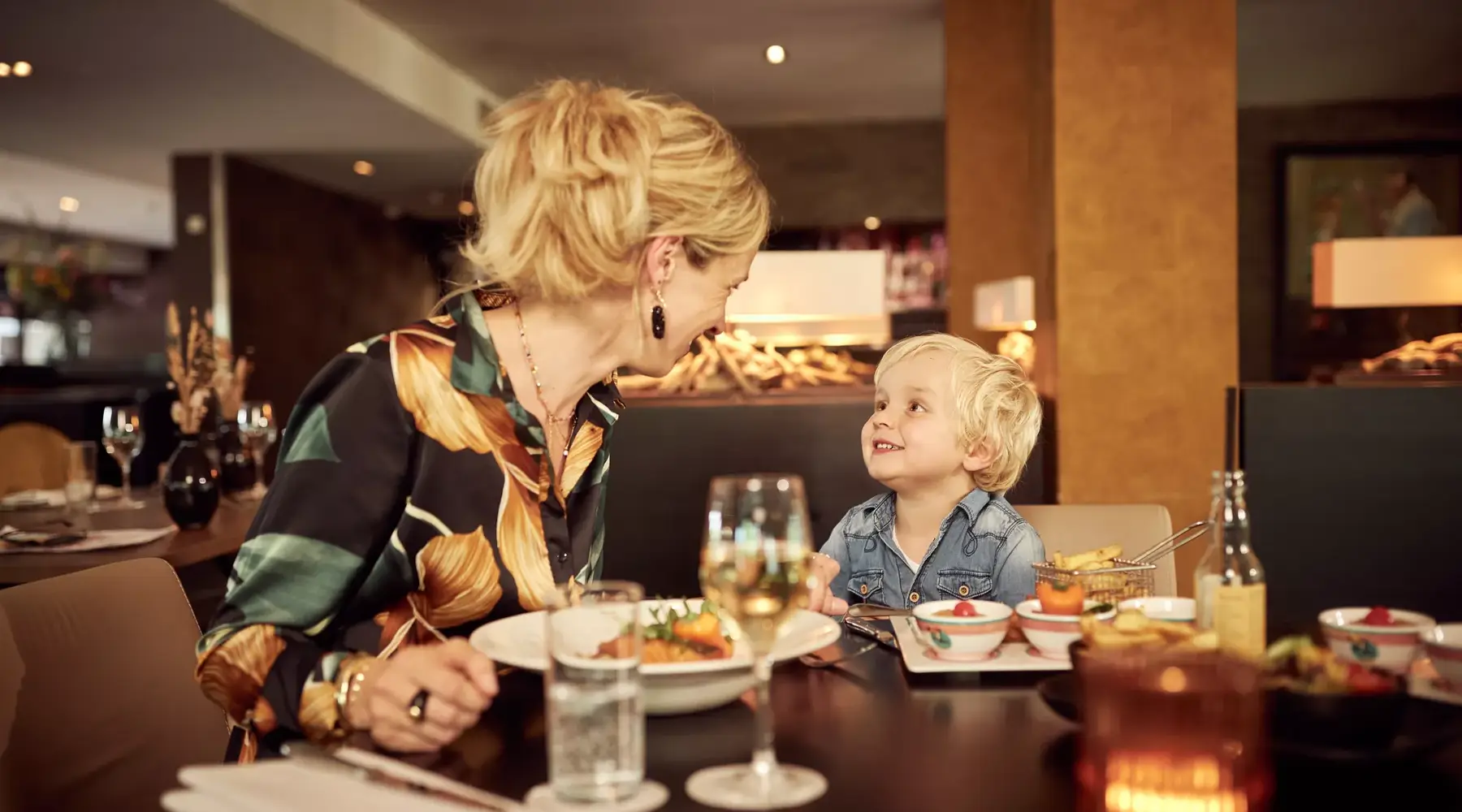 Mother and child smile at each other at the table.