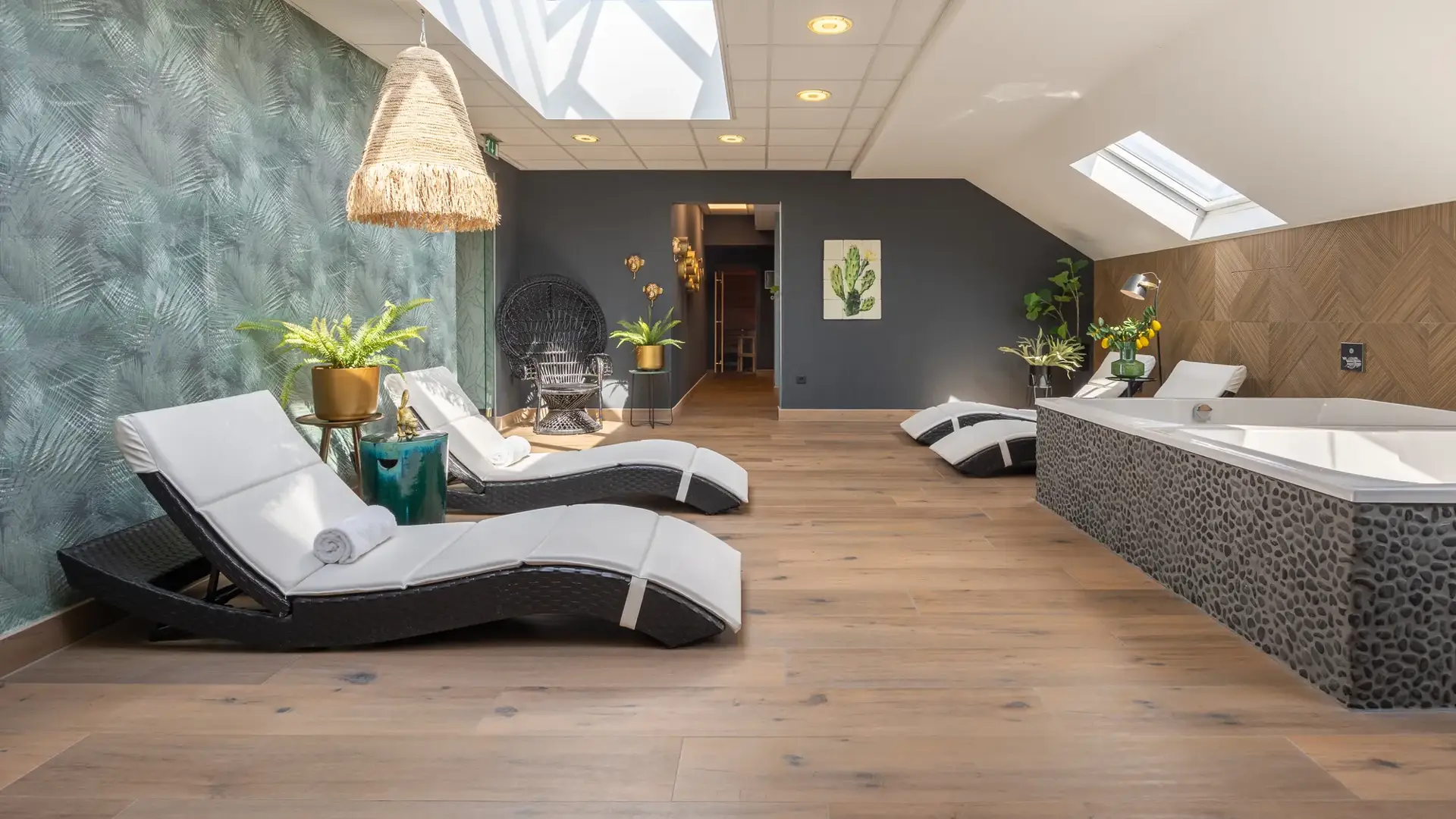 Auf dem Foto sind 2 Whirlpools und einige Liegestühle im Wellnessbereich zu sehen.