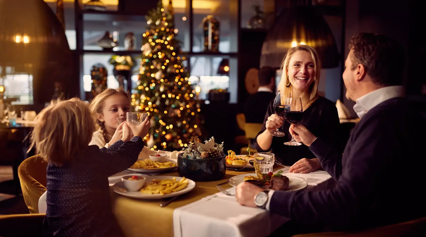 Gezin aan tafel tijdens kerstdiner.
