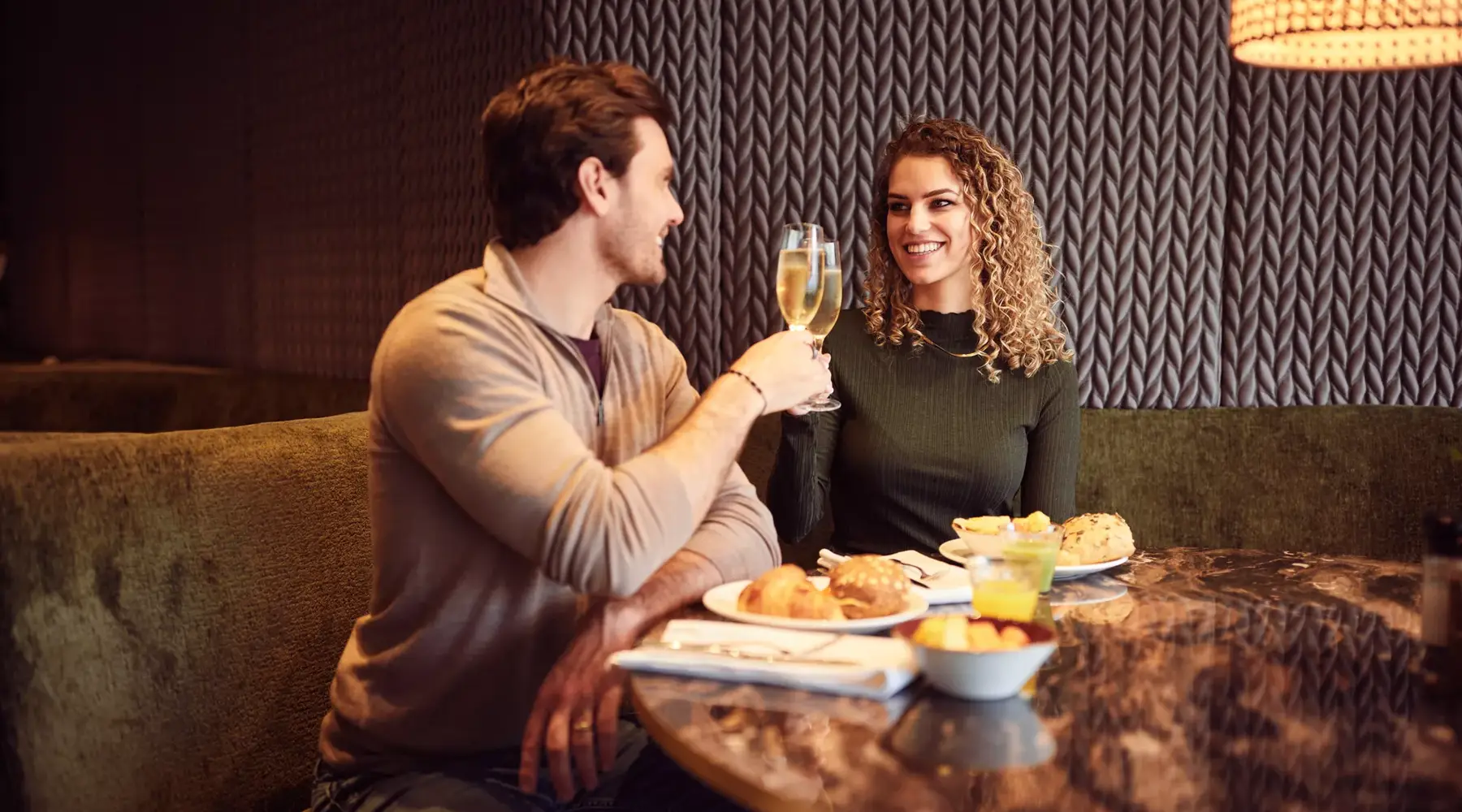Man en vrouw proosten met champagne tijdens een nieuwjaarsontbijt
