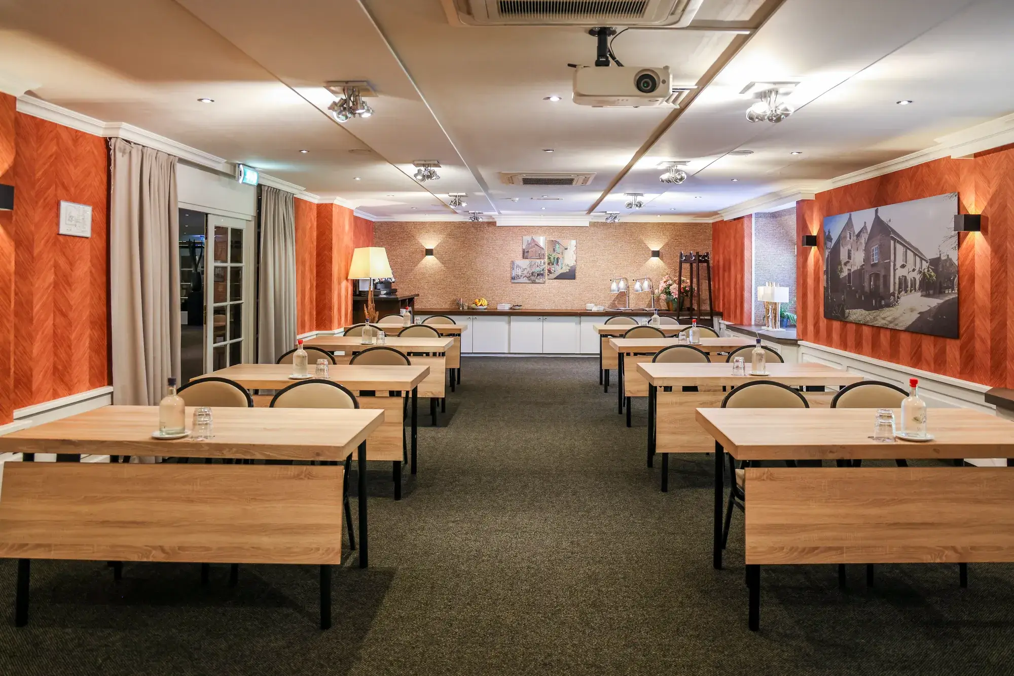 Vue d'ensemble des aménagements scolaires confortables dans le hall, avec les installations pour le café et les boissons en arrière-plan.