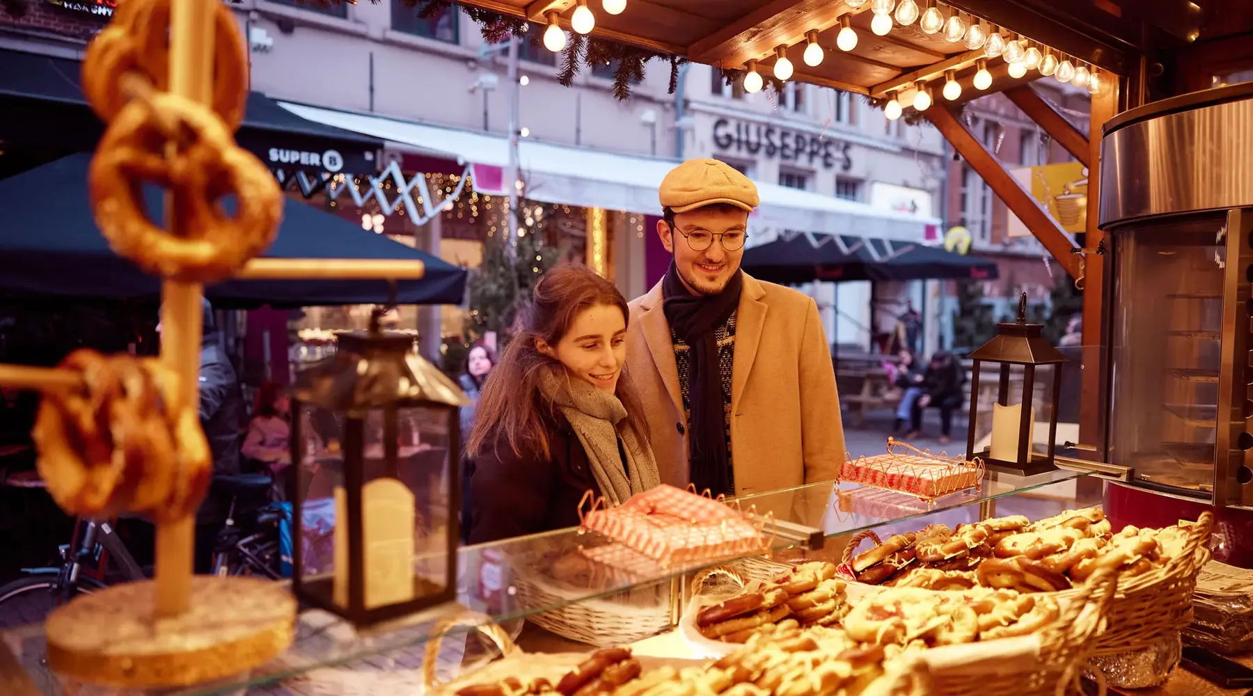 Een stel op een kerstmarkt bij een kraampje