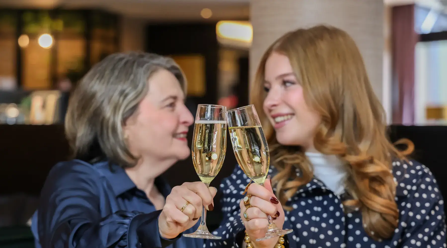 Mutter und Tochter stoßen mit Champagner an