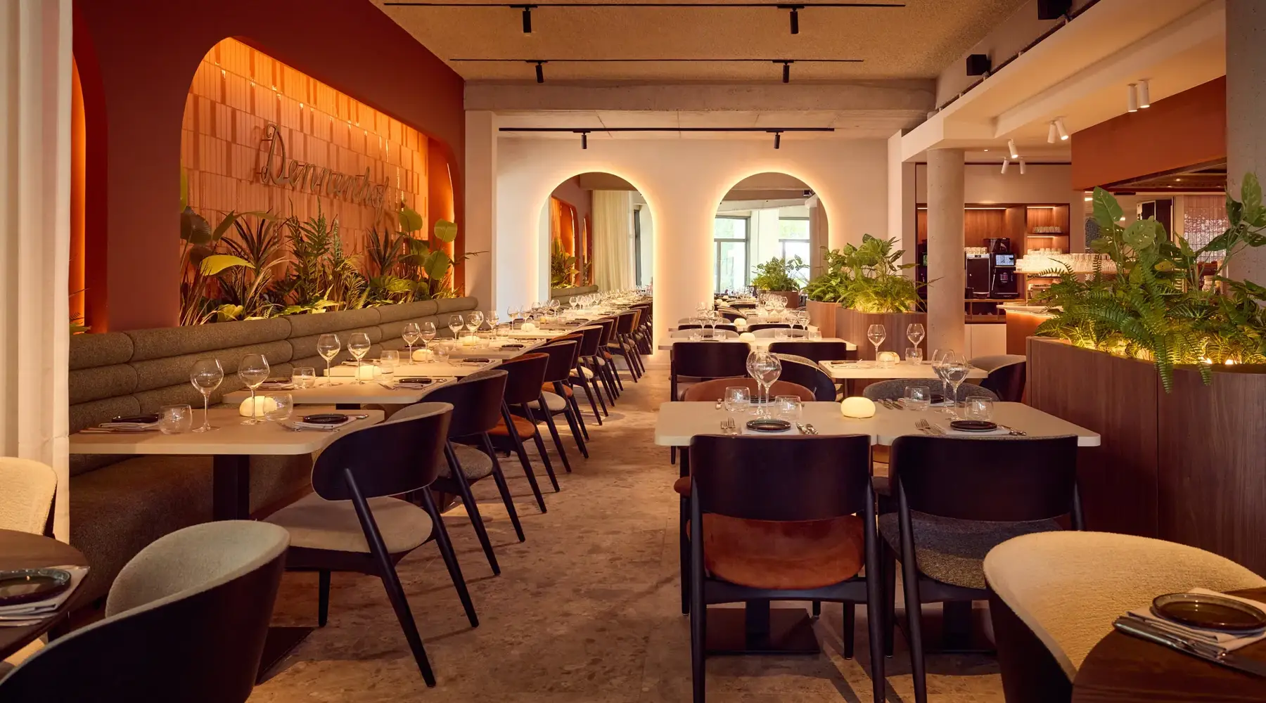 Restaurant Hotel Dennenhof. Brown chairs and wooden tables set with glasses and napkins.